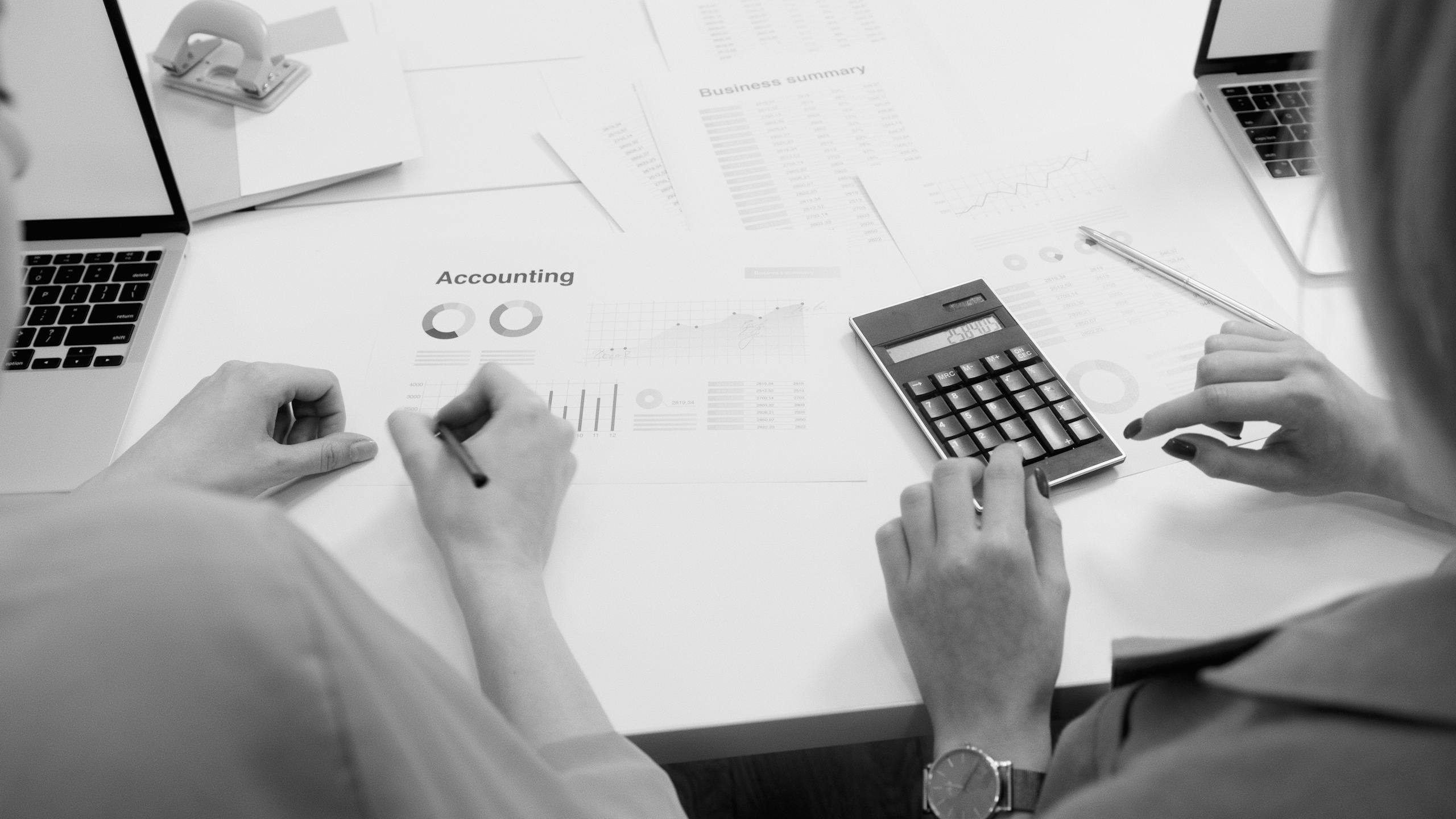 Accountant analyzing financial documents with a calculator on a desk, highlighting business tasks.